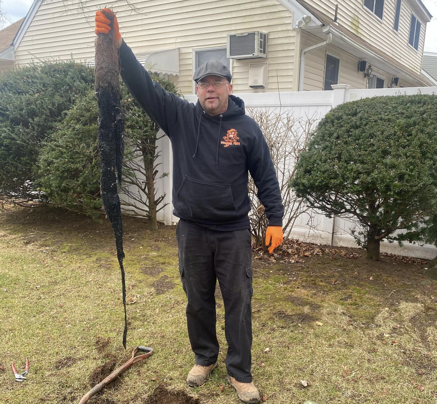 owner of Cesspool Pros holding a clog from sewer