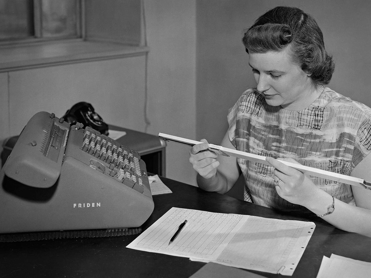 A female computer at the National Advisory Committee for Aeronautics Lewis Flight Propulsion Laboratory with a slide rule and Friden adding machine to make computations