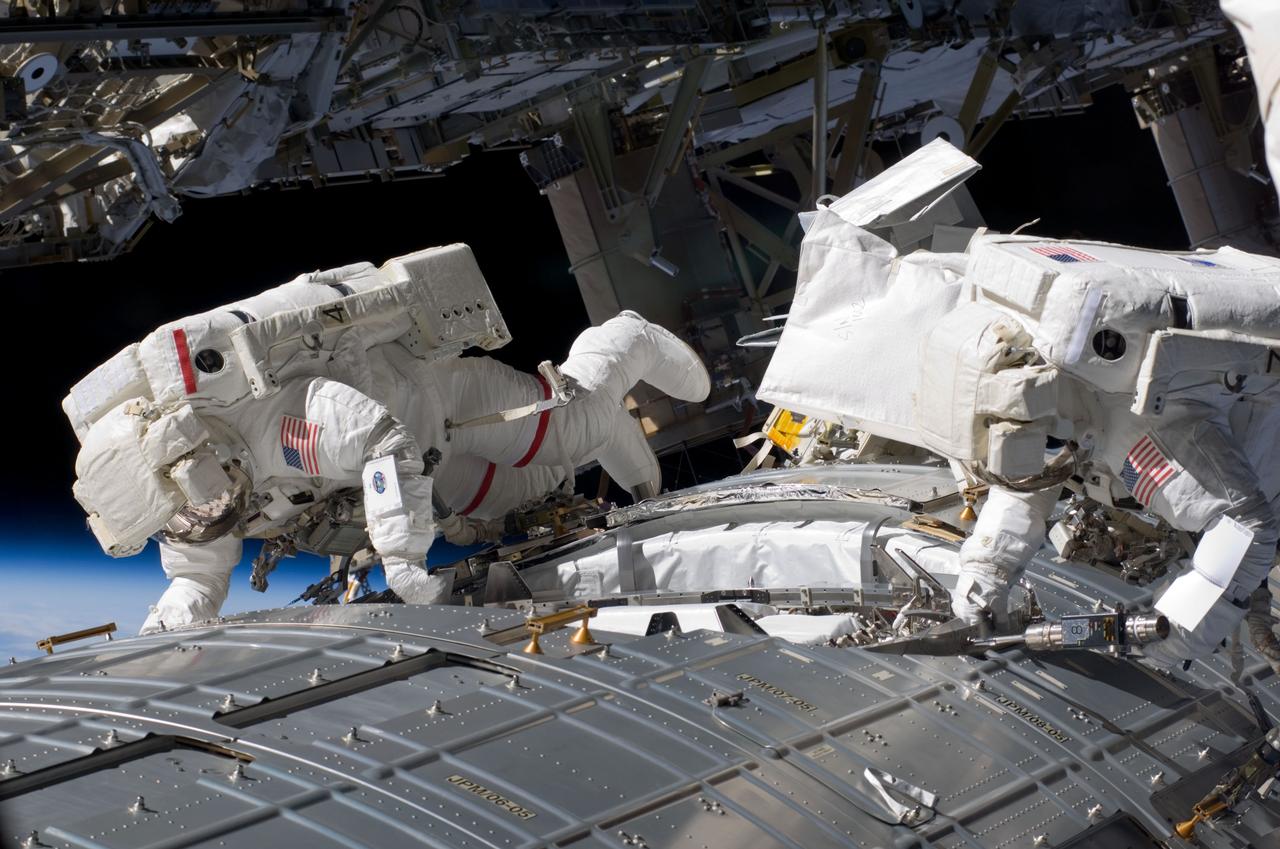 two astronauts doing maintenance on the international space station - concept to match Logic Web Media space themed web design